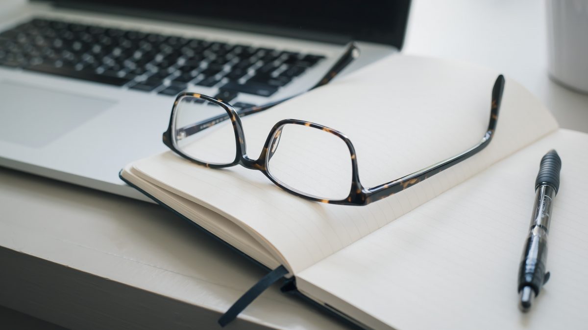 black framed eyeglasses and black pen