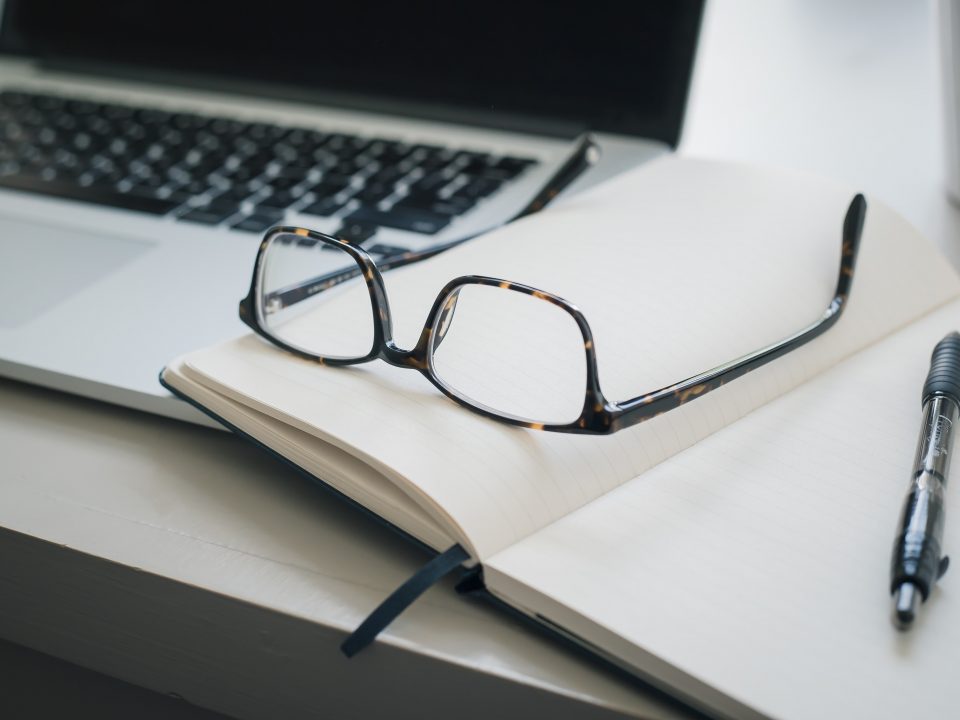 black framed eyeglasses and black pen